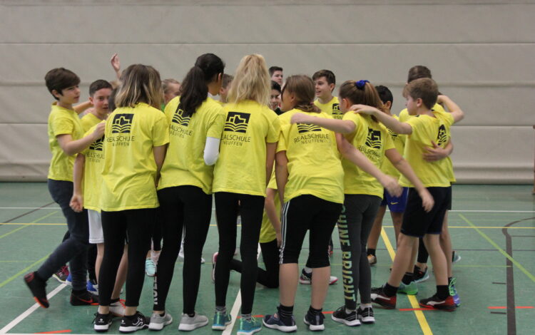 Schülerinnen und Schüler im Sportunterricht machen einen Kreis um sich zu motivieren