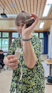 Eine Lehrerin hält eine Fledermaus in der Hand