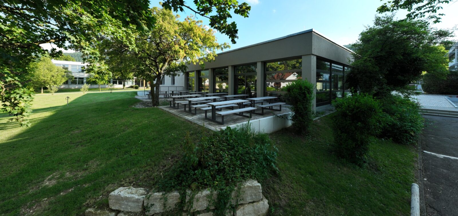 Mensagebäude mit Außenbereich wo man sitzen und essen kann.