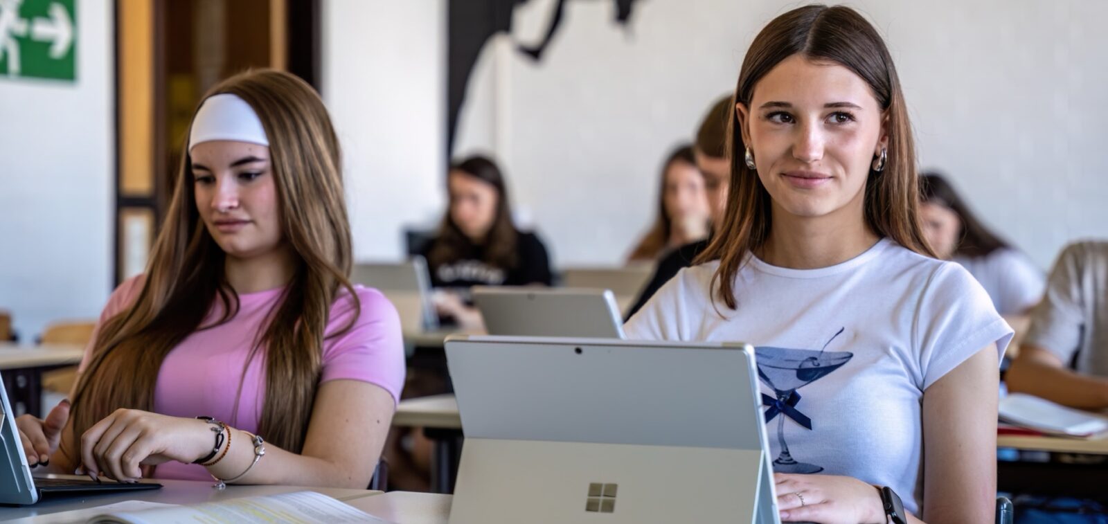 Mehrere Mädchen arbeiten in einem Klassenzimmer an Tabletrechnern