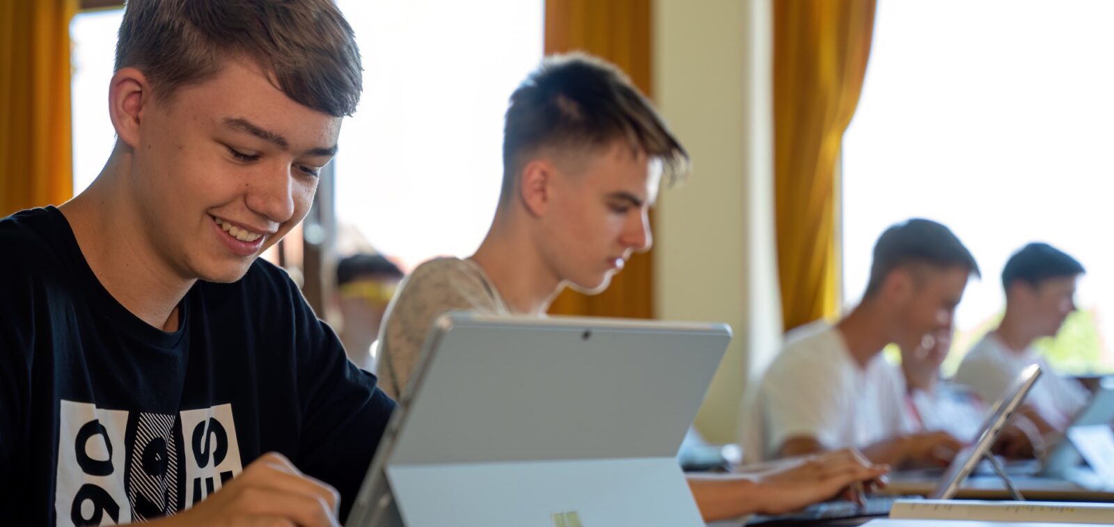 Mehrere Schüler arbeiten mit Tablets