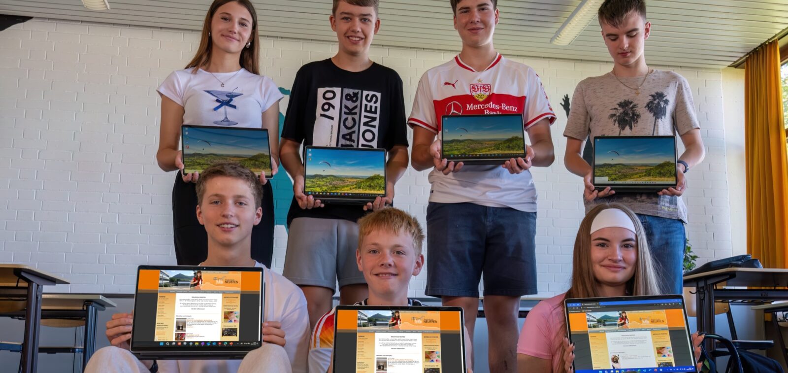 Sieben Schülerinnen und Schüler zeigen ihre Tablets